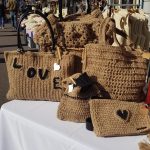 Photo du stand à une manifestation avec des sacs et pochettes crochetés