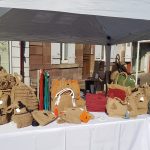 Photo du stand à une manifestation avec des sacs et pochettes crochetés