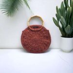 Maria Sac rond crochetée en fil coton à macramé 100% recyclé avec anses rondes en bambou pour un porté à la main ou au bras.