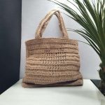 Stephania Sac cabas rectangulaire crocheté en ficelle de jute de couleur beige avec un cœur ajouré sur l'avant du sac.