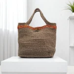 Arabella Sac cabas crocheté en ficelle de jute beige avec une bordure en jute rouge, jaune et orange.